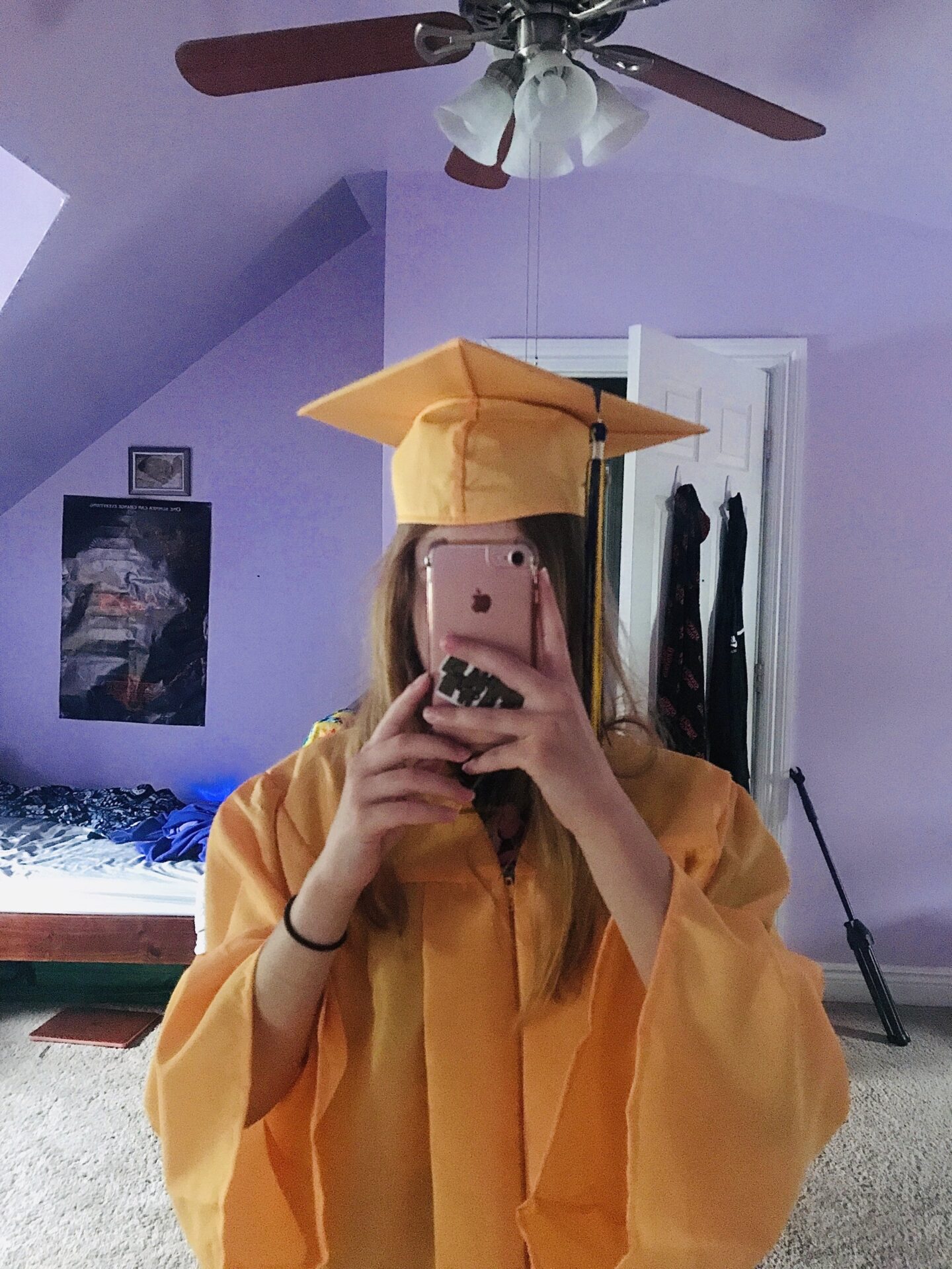 Grad taking picture with cap and gown to send for graduation.