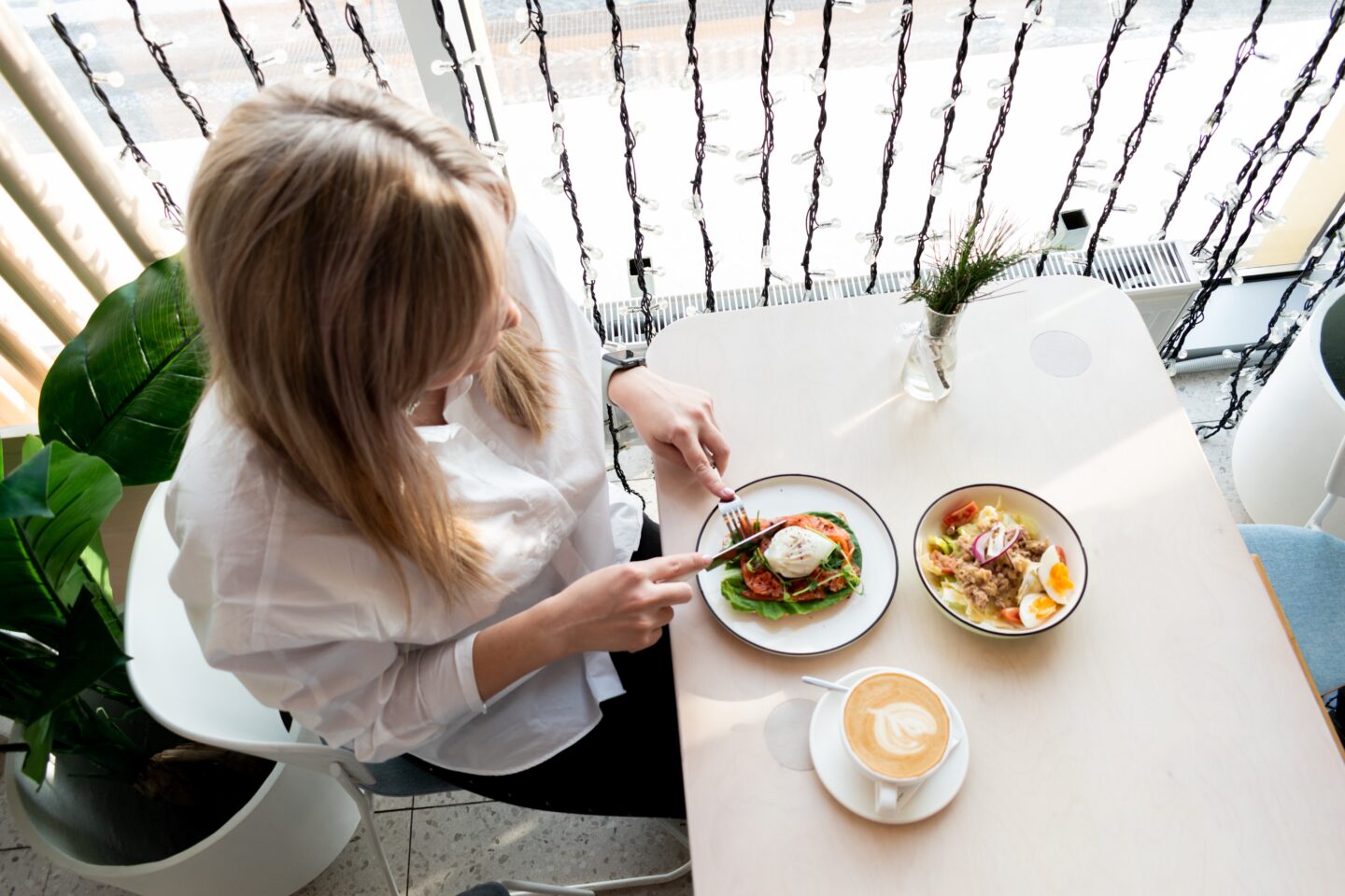 Girl eating lunch sitting near a window