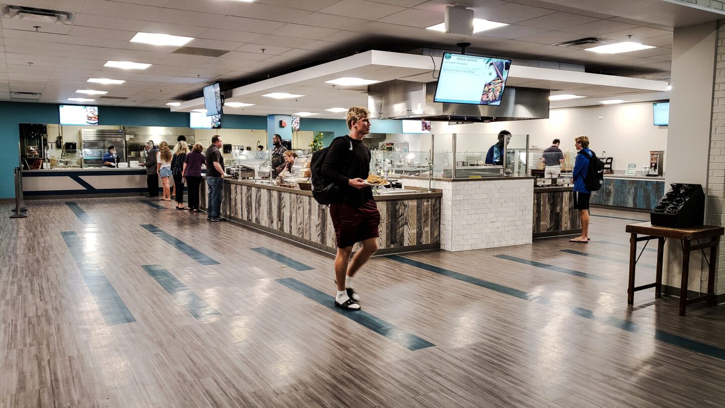 A dining hall at a college campus with students picking food